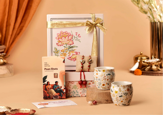 Gift set with floral design, Rakhi Lumba set, cards, and decorative items on a beige background